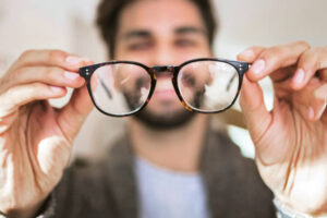 Persona observando a través de unos lentes para ilustrar errores refractivos como miopía, hipermetropía y astigmatismo